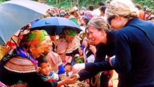 Des touristes étrangères échangeant de manière amicale avec des femmes H'Mong au marché de Bắc Hà.