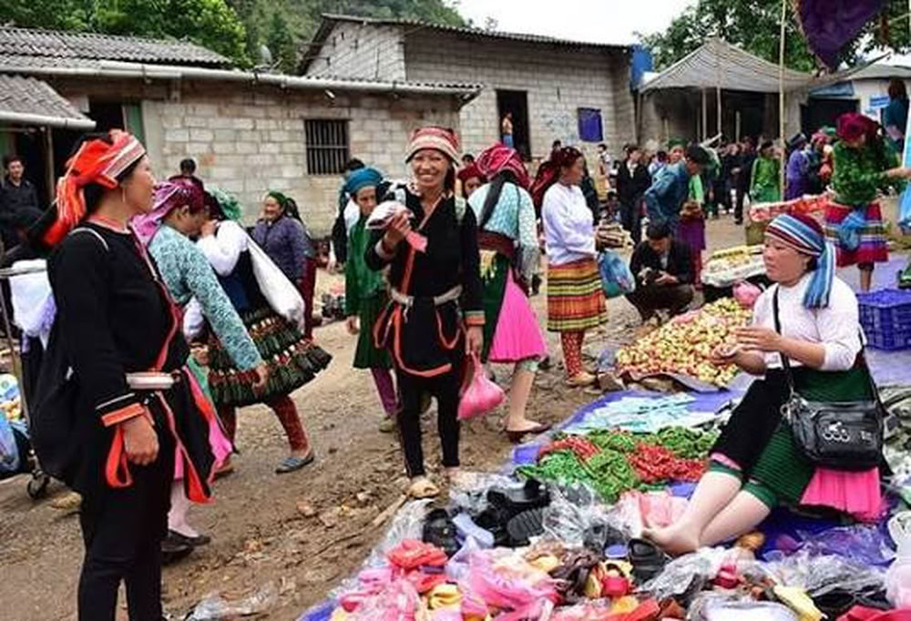 Ambiance vivante des étals de chaussures et tissus au marché périodique de Lũng Phìn.