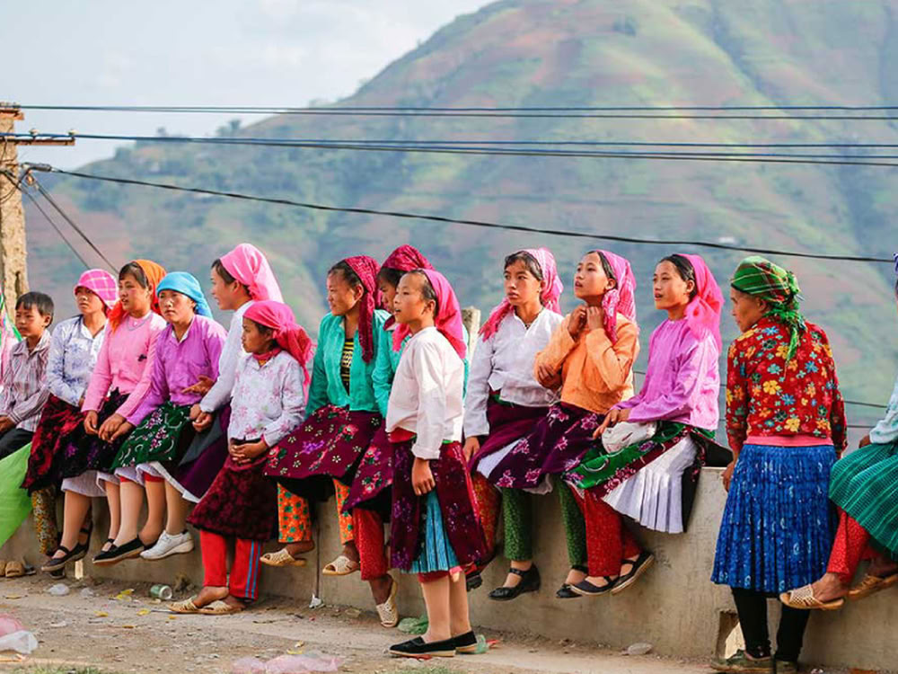 Jeunes filles ethniques en tenues traditionnelles colorées assises ensemble au marché de l'amour de Khâu Vai.