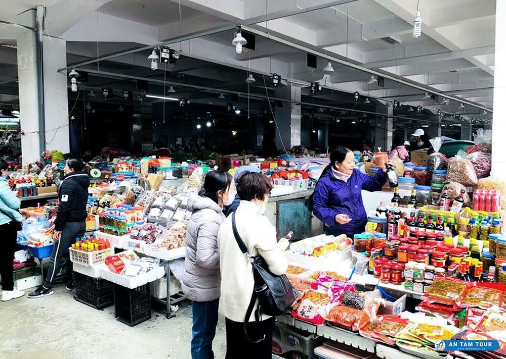 Vendeuse présentant des épices et sauces locales.